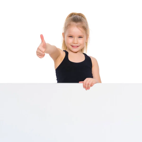 La bambina punta il dito contro uno striscione bianco . — Foto Stock