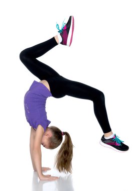 Jimnastikçi bükülmüş bacaklarıyla amuda kalkar..