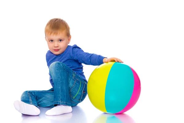 Um menino está brincando com uma bola . — Fotografia de Stock