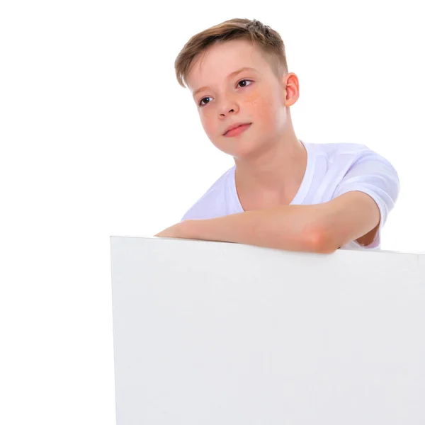 Хлопчик шкільного віку біля білого рекламного банера . — стокове фото