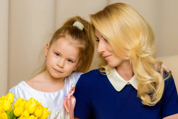 Moeder en dochtertje met een boeket van tulpen. — Stockfoto