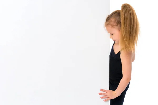 Una bambina sta guardando da dietro uno striscione vuoto. — Foto Stock