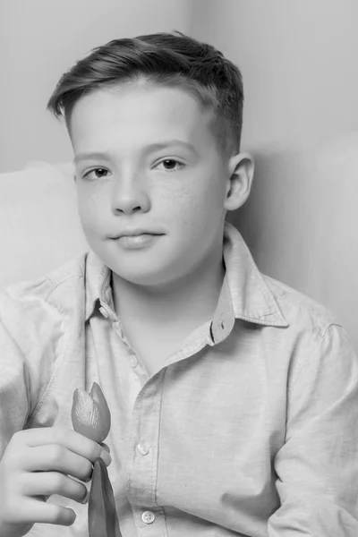 A boy of school age with a flower of a tulip. — Stock Photo, Image