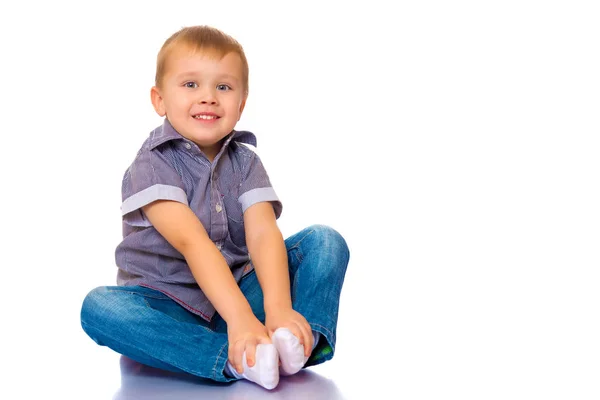 O menino está sentado no chão. — Fotografia de Stock