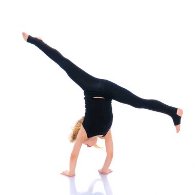 Kız jimnastikçi bir hareketten gerçekleştirir.