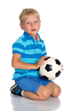 Küçük çocuk bir futbol topuyla oynuyor.