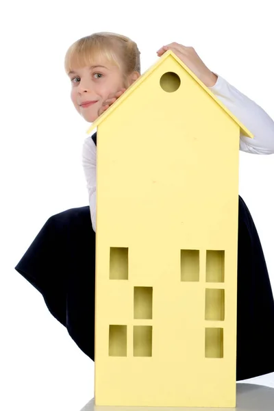 Little girl is playing with wooden houses. — Stock Photo, Image