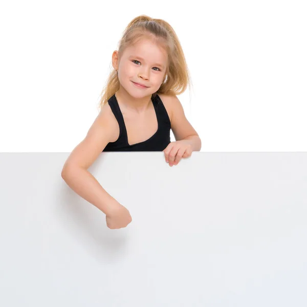 A little girl is looking from behind an empty banner. — Stock Photo, Image