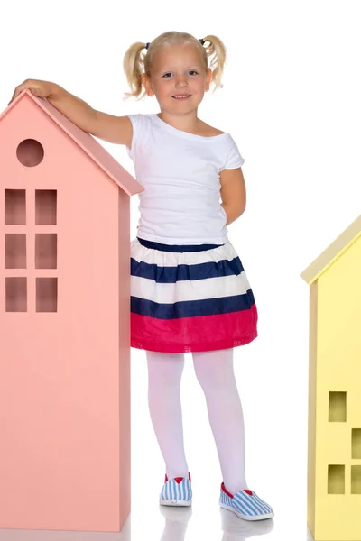 Little girl is playing with wooden houses. — Stock Photo, Image