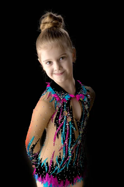 Bambina ginnasta in un bellissimo costume da bagno sportivo su un ba nero — Foto Stock