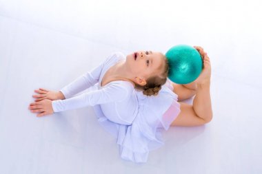 Jimnastikçi yerde akrobatik bir element sergiliyor..