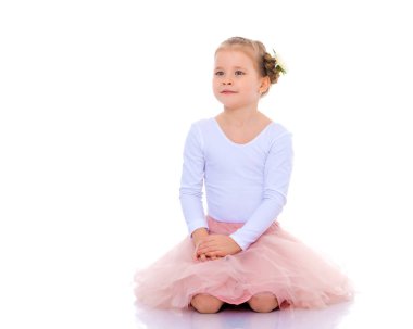 Küçük kız yerde oturuyor..