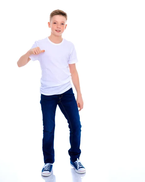 Chłopiec szkoły wskazuje na jego biały T-shirt. — Zdjęcie stockowe