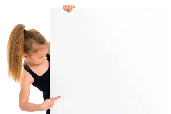 Little girl points a finger at a white banner. — Stock Photo, Image