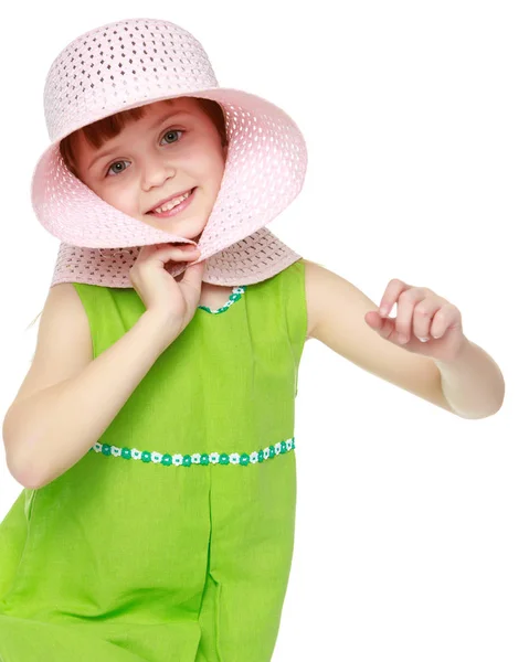 Uma menina está posando em um chapéu de palha de praia . — Fotografia de Stock