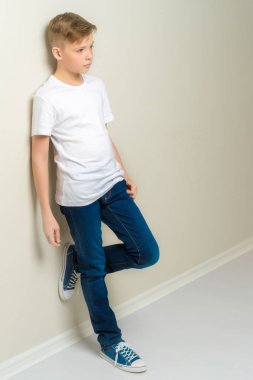 Bir moda okul çağındaki çocuk duvara yaslandı.