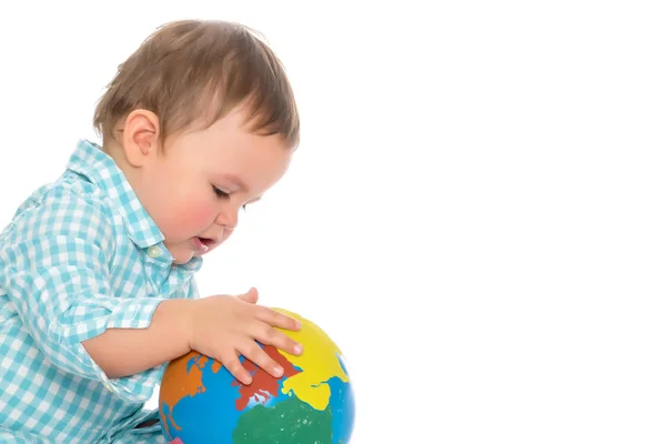 Un petit garçon joue avec un globe . — Photo
