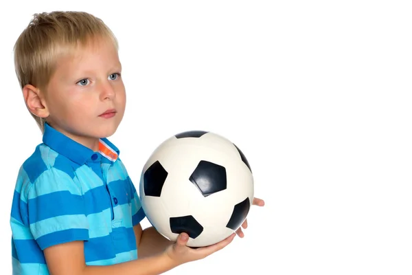 Menino está jogando com uma bola de futebol . — Fotografia de Stock