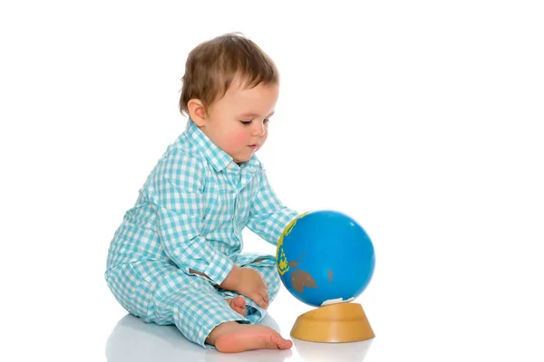 A little boy is playing with a globe. — Stock Photo, Image