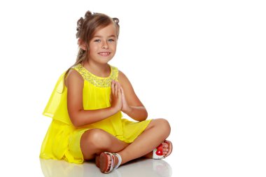 Küçük kız yerde oturuyor..