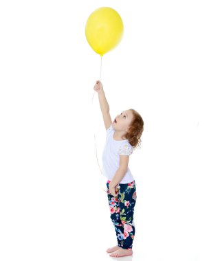 Küçük kız bir balonla oynuyor.