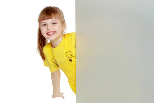 Dziewczyna z krótką grzywką na jej głowie i jasny żółty kombinezon. — Zdjęcie stockowe
