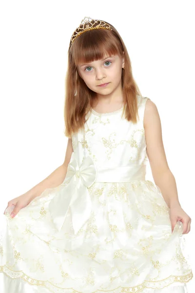 A menina está segurando as bordas do vestido com as mãos . — Fotografia de Stock