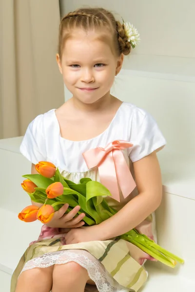 Маленька дівчинка з букетом тюльпанів . — стокове фото