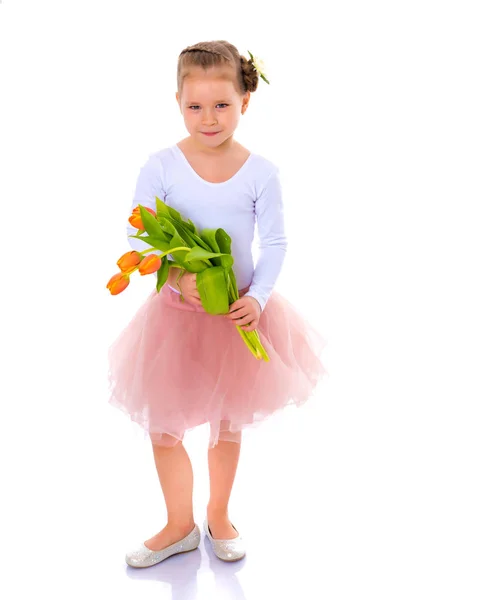 Kleines Mädchen mit einem Strauß Tulpen. — Stockfoto