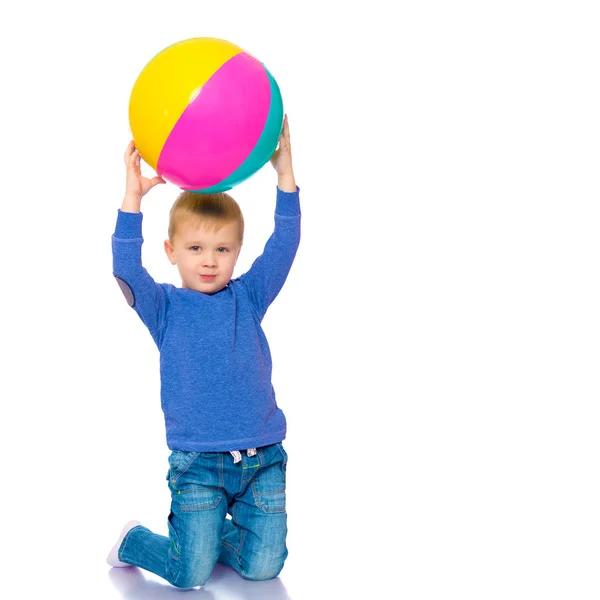 Um menino está brincando com uma bola . — Fotografia de Stock