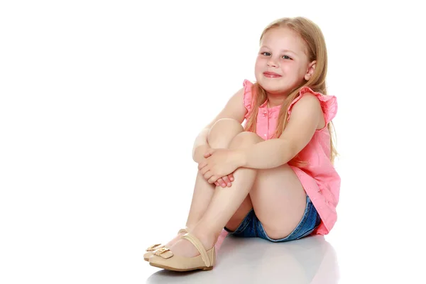 Klein meisje zit op de vloer.. — Stockfoto