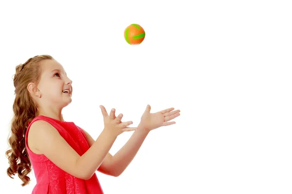 Das kleine Mädchen wirft den Ball hoch — Stockfoto