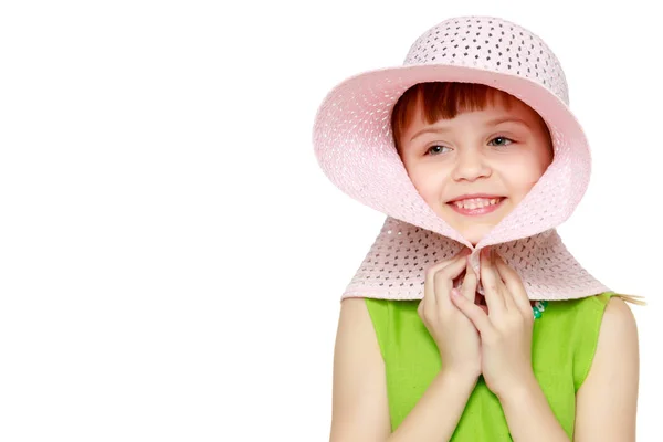 Uma menina está posando em um chapéu de palha de praia . — Fotografia de Stock