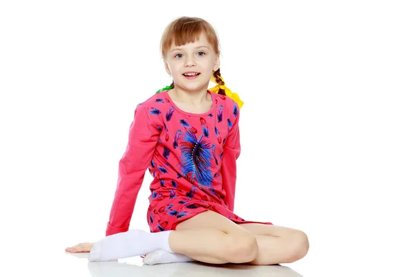 Ragazza si siede sul pavimento e guarda direttamente la fotocamera . — Foto Stock