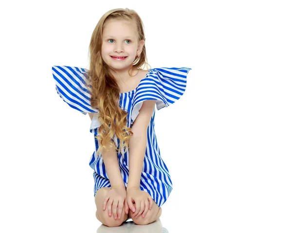 Entzückende kleine blonde Mädchen in sehr kurzen Sommer gestreiften Kleid. — Stockfoto