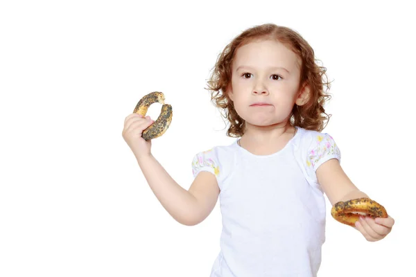 Liten flicka äter en bagel — Stockfoto