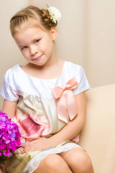 Little girl is sitting on the couch — Stock Photo, Image