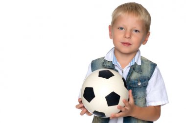 Küçük çocuk bir futbol topuyla oynuyor.