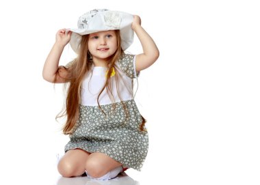 Küçük kız yerde oturuyor..