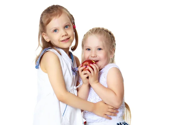 Dwie dziewczynki z jabłkiem — Zdjęcie stockowe