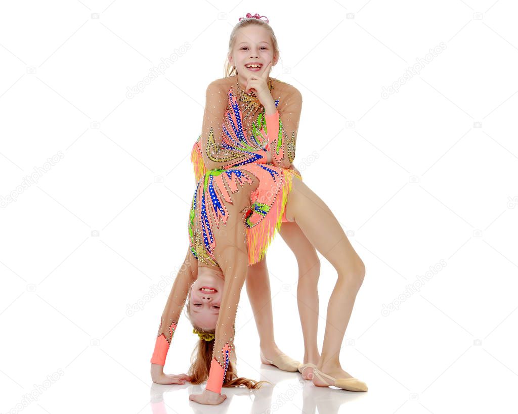 Two girls gymnast doing a bridge.