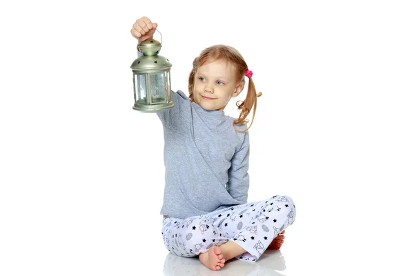 Küçük bir kız bir lamba tutuyor. — Stok fotoğraf
