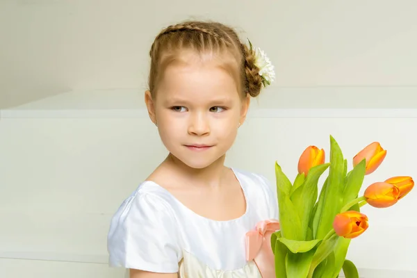 Little girl with a bouquet of tulips. — Stock Photo, Image