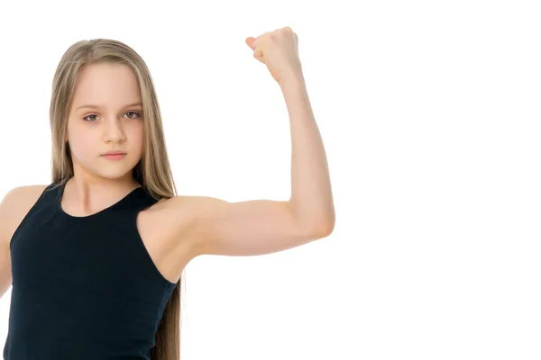 Una niña pequeña muestra sus músculos . — Foto de Stock