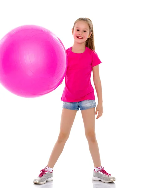 Kleines Mädchen macht Übungen auf einem großen Ball für Fitness. — Stockfoto