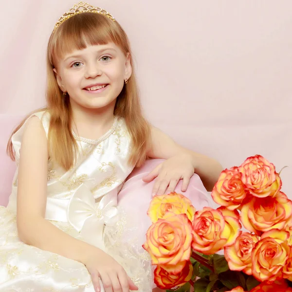 Girl sits next to a bouquet of flowers. — Stock Photo, Image