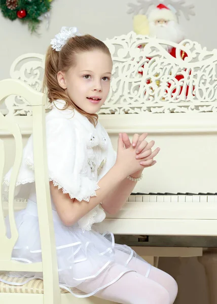 Menina em um piano Grand branco . — Fotografia de Stock