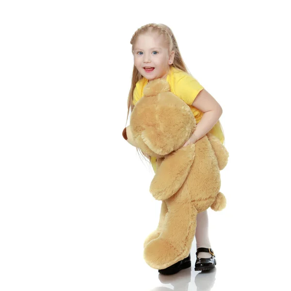 Menina abraços um grande ursinho de pelúcia . — Fotografia de Stock