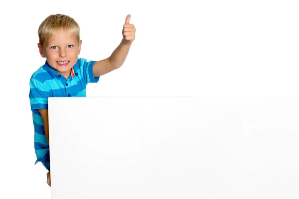 A little boy is looking from behind an empty banner. — Stock Photo, Image