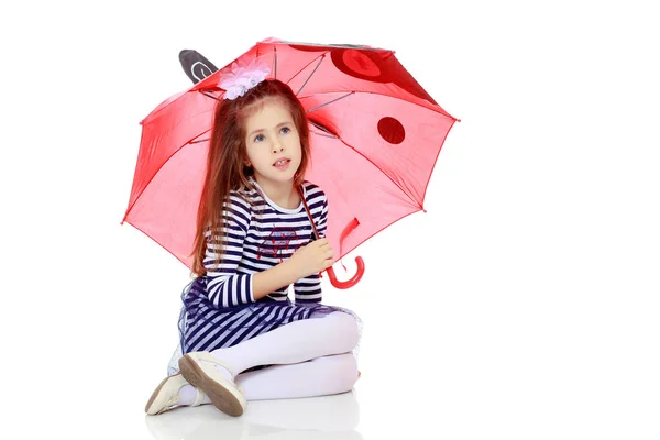 Meisje verstopt onder een paraplu. — Stockfoto